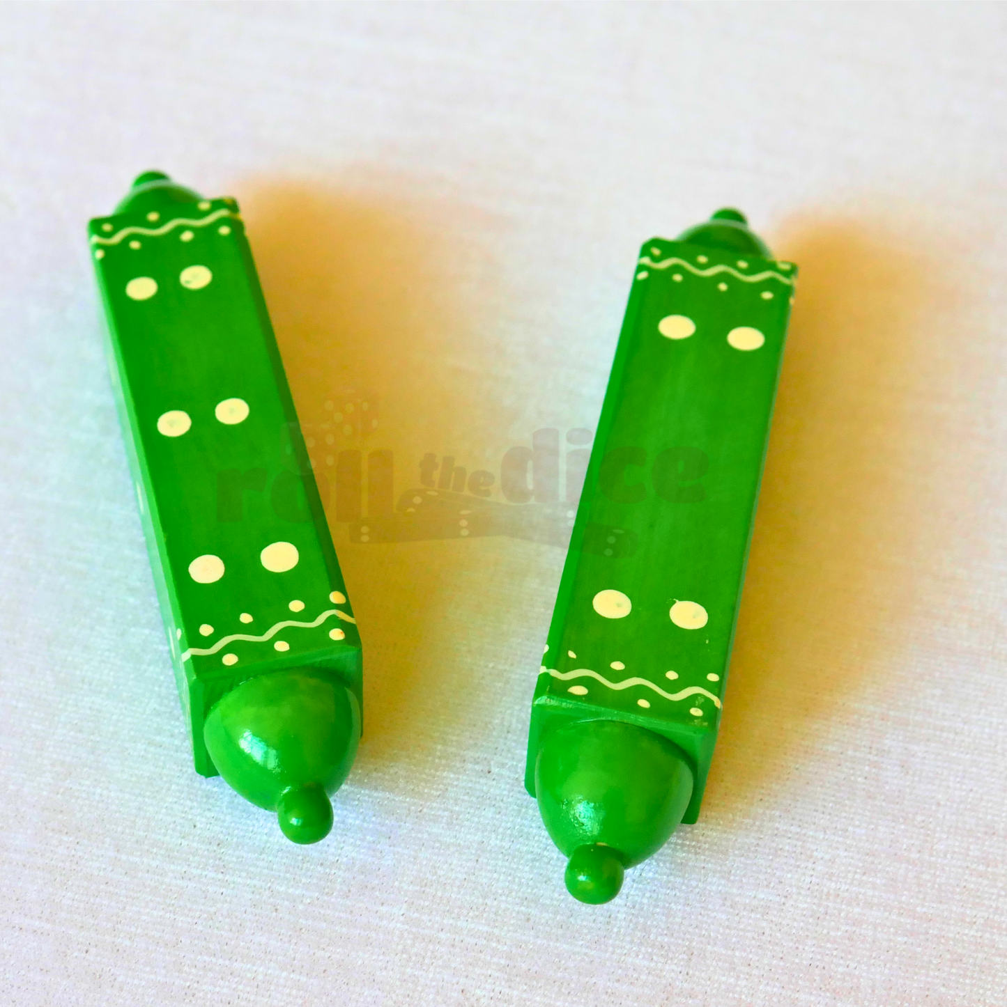 Green Special daaLa long dice by Roll the Dice showing multiple sides with engraved numbers for gaming.