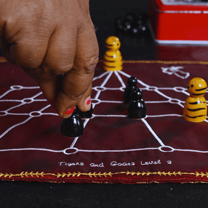 Heritage Aadu Huli board game featuring tiger and goat pieces, by Roll the Dice, showing colorful game components and traditional design.