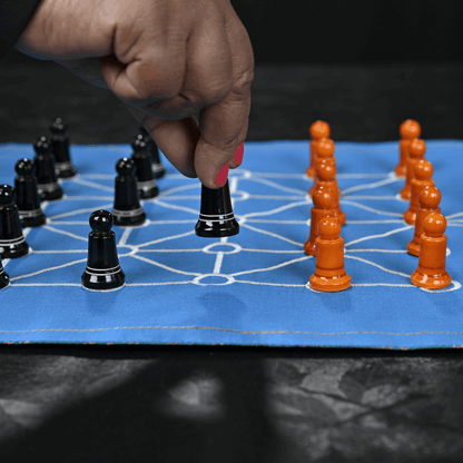 SholoGutti board game featuring sixteen soldiers with colorful game pieces on a wooden board.